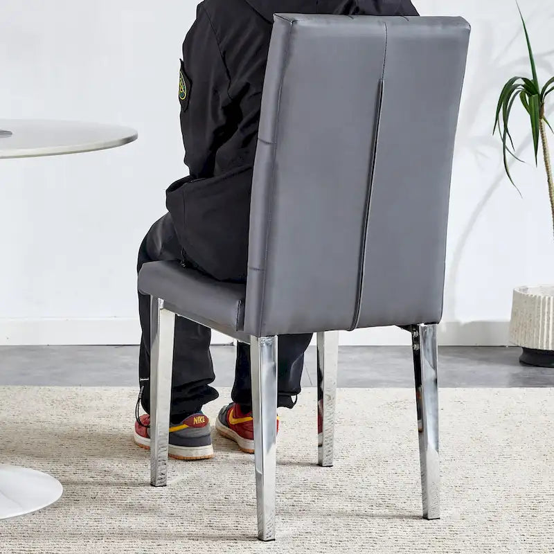 Cet ensemble de 4 chaises de salle à manger grises sans accoudoirs apporte une touche d'élégance et de mystère à la salle à manger grâce à son ton gris profond.